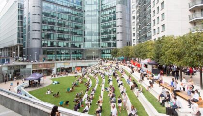 people sitting on grass stepped terrace outside office building